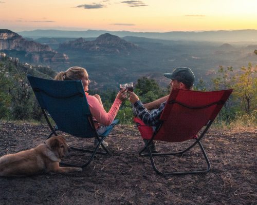 two person sitting on camping chairs while watching mountain
